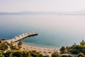 een strand met stoelen en parasols op het water bij Brown Beach Chalkida, a member of Brown Hotels in Chalkida