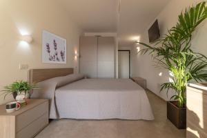 una camera con un letto e due piante in vaso di Casa vacanze Le Querce a Castiglione della Pescaia