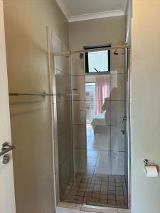a shower with a glass door in a bathroom at Gallagher Midrand BnB in Midrand