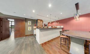 una cocina con paredes rosas y un bar con sillas en Delta Hotels by Marriott Baltimore North, en Baltimore