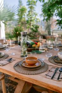 una mesa de madera con copas de vino y un tazón en ella en San Roque Suites de Monda, en Monda