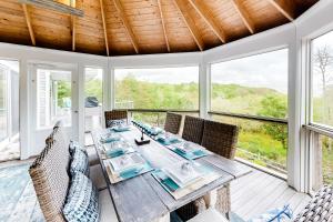 a dining room with a table and chairs and windows at Water Overlook in Oak Bluffs