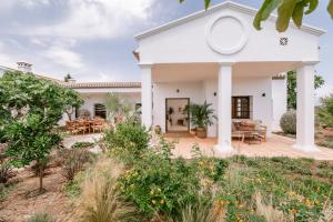 a white house with a deck and patio at San Roque Suites de Monda in Monda