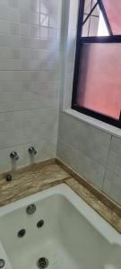 uma casa de banho com uma banheira e uma janela em Apartamento/ flat em São Vicente em São Vicente