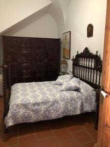 - une chambre avec un grand lit et une tête de lit en bois dans l'établissement La Posá, à La Nava de Santiago