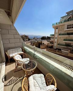 a balcony with chairs and beds on a building at Sea side 87 Sweet Me Eilat אילת in Eilat