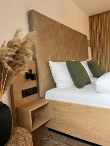 sypialnia z łóżkiem z białymi i zielonymi poduszkami w obiekcie MINAROSO appartements am badeparadies -ehemalig Kaltenbachs Appartements w mieście Titisee-Neustadt
