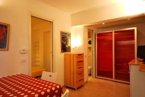 1 dormitorio con 1 cama y puerta corredera de cristal en Appartamenti family & MTB en Finale Ligure