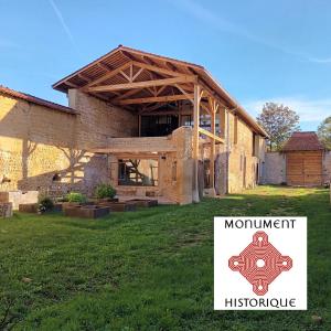 un bâtiment avec un panneau devant lui dans l'établissement La ferme de Berlioz, à La Côte-Saint-André