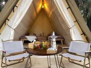 een tafel en twee stoelen in een tent bij Husaak Glamping in Al Ula