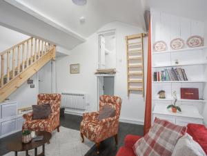 a living room with two chairs and a staircase at 4 Ty Person in Bethesda