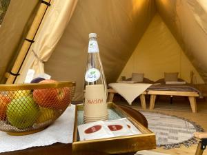 a bottle of alcohol sitting on a table in a tent at Husaak Glamping in AlUla