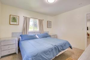 a bedroom with a bed with blue sheets and a window at Steps to Deerfield Beach Home with Private Patio! in Deerfield Beach