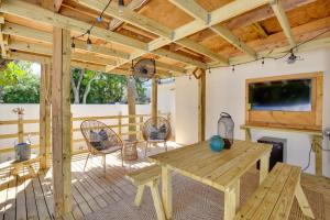 a wooden deck with a table and chairs and a fireplace at Steps to Deerfield Beach Home with Private Patio! in Deerfield Beach