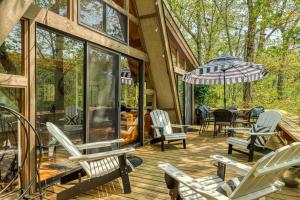 a wooden deck with chairs and an umbrella at 1236 Hideaway Lake Chalet by Sarah Bernard Chalets with Private Dock and Hot Tub in Innsbrook