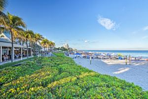 a beach with people and umbrellas and the ocean at Steps to Deerfield Beach Home with Private Patio! in Deerfield Beach