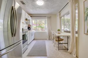 a kitchen with a table and a refrigerator at Chic Deerfield Beach Cottage - Walk to Beach! in Deerfield Beach