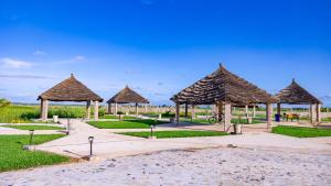 a group of pavilions with straw umbrellas at Seaview Superior Room in Cape Point Bakau in Bakau