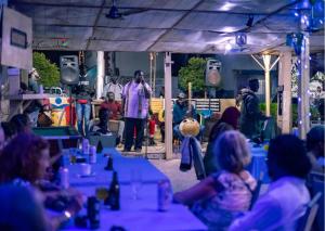 a group of people sitting at tables in a room at Seaview Superior Room in Cape Point Bakau in Bakau