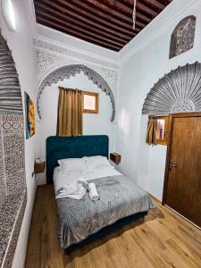 a bedroom with a bed with a blue headboard at DAR SABA in Rabat