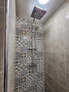 a bathroom with a shower with a tiled wall at DAR SABA in Rabat