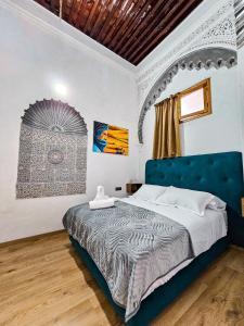 a bedroom with a large bed with a blue headboard at DAR SABA in Rabat