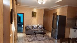 a living room with a couch and a refrigerator at Cottage Green Garden in Tsaghkadzor