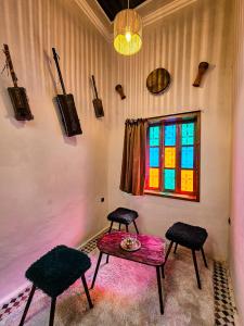 um quarto com duas cadeiras, uma mesa e uma janela em DAR SABA em Rabat