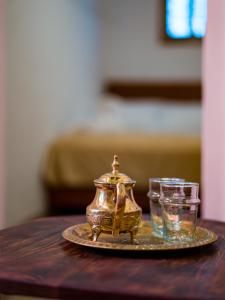 a tea pot and two glasses on a table at DAR SABA in Rabat