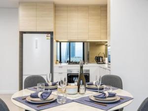 a dining room table with chairs and a kitchen at Location Oceanview luxury 1BR Apt steps to beach in Gold Coast