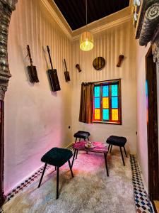 um quarto com uma mesa e duas cadeiras e uma janela em DAR SABA em Rabat