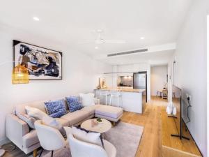 een woonkamer met een bank en een tafel bij Conveniently located 2BR apt with rooftop pool at Milt in Brisbane