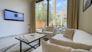 salon z kanapą i telewizorem w obiekcie Duplex Ana - Appartement design à Marrakech w Marakeszu