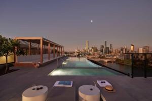 a swimming pool on top of a building with a city skyline at Conveniently located 2BR apt with rooftop pool at Milt in Brisbane