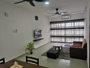 a living room with a couch and a ceiling fan at Apartment Alor Gajah in Kampong Alor Gajah