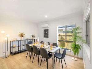 a dining room with a white table and chairs at Well-decorated 4BR Family home steps to mall in Browns Plains