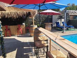 - une piscine avec des chaises longues et des parasols à côté de la piscine dans l'établissement Tropical Paradise, à Fresno