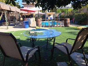 una mesa de cristal y 2 sillas con un parque infantil en Tropical Paradise, en Fresno