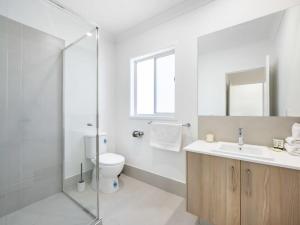 a bathroom with a toilet and a sink and a shower at Well-decorated 4BR Family home steps to mall in Browns Plains