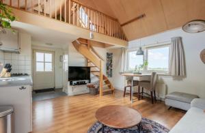 a kitchen and a living room with a spiral staircase at Molenzicht in Sint Maarten