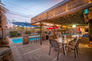 une terrasse avec une table, des chaises et une piscine dans l'établissement Tropical Paradise, à Fresno