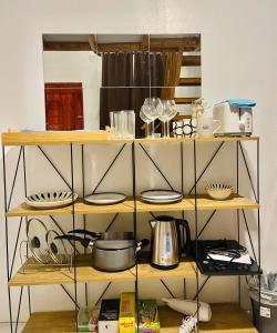 a shelf filled with pots and pans and dishes at ANDRO'S LOFT near General Santos City Airport in General Santos