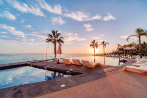 una piscina con palmeras y el océano en Suite 107 - Two bedroom apartment, en Funchal