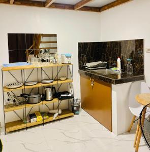 a kitchen with a counter and a shelf with dishes at ANDRO'S LOFT near General Santos City Airport in General Santos