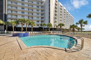 a swimming pool in front of a large building at Mainsail 131 - Beachfront 2BR with Free Seasonal Beach Service in Destin