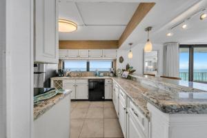 a kitchen with white cabinets and a view of the ocean at Mainsail 131 - Beachfront 2BR with Free Seasonal Beach Service in Destin