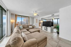 a living room with a couch and a flat screen tv at Mainsail 131 - Beachfront 2BR with Free Seasonal Beach Service in Destin