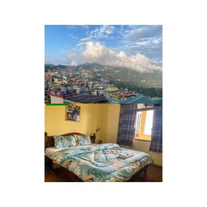 a bedroom with a bed and a view of a city at King Thai Hotel and Restaurant in Kalimpong