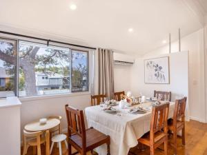 uma sala de jantar com mesa e cadeiras em Family friendly cozy 4BR house at Annerley em Brisbane