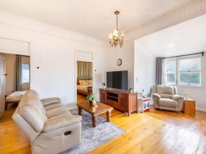 a living room with a couch and a tv at Family friendly cozy 4BR house at Annerley in Brisbane